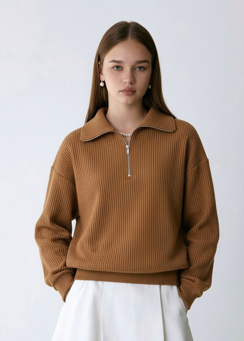 Woman wearing a brown ribbed sweater against a white background